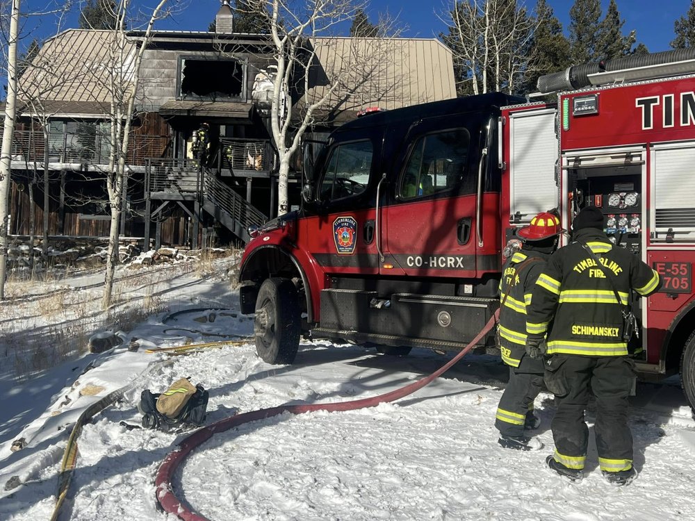 Timberline engine and firefighters working a house fire in winter